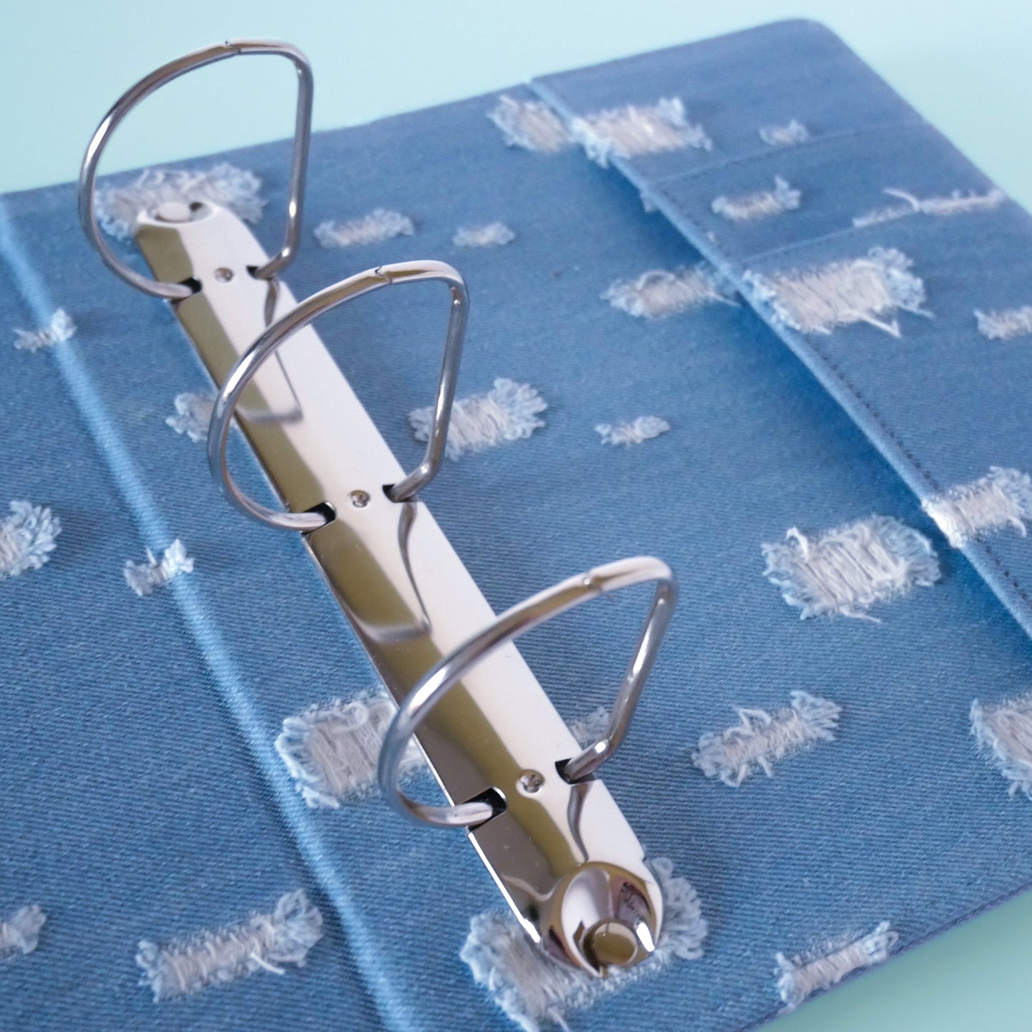 Blue binder with metal rings on a green blue background