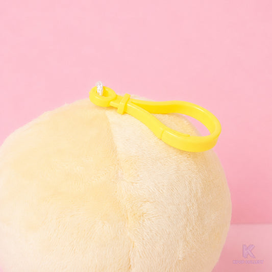 A close-up detail of the yellow attachment clip on the top of the fluffy Stray Kids Felix BbokAri plush keychain