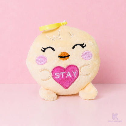 A direct, front-facing view of the Stray Kids Felix BbokAri plush keychain. The adorable yellow chick character is holding a small pink heart with the word 'STAY' embroidered on it.