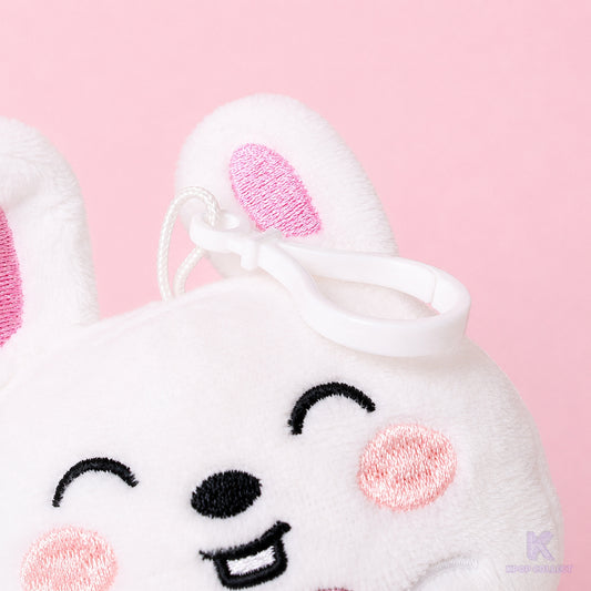 A close-up detail of the attachment clip on the top of the fluffy Stray Kids Lee Know Leebit plush keychain, showing the hardware and the bunny's face.